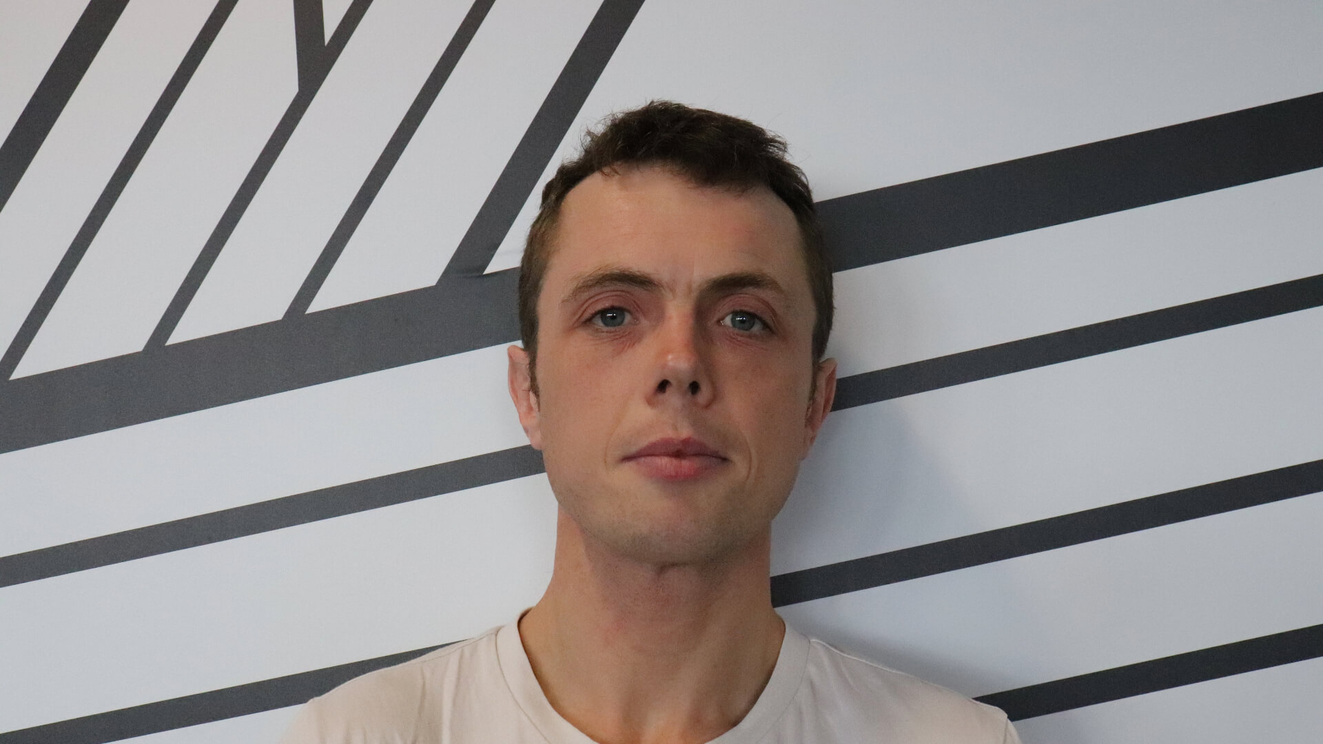 A head and shoulders picture of Michael Hunter, escape studios photography tutor, in front of the black and white escape studios walls