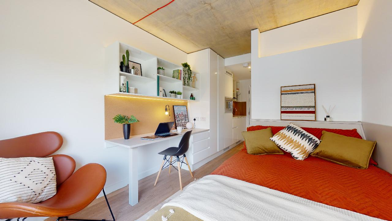 A studio bedroom at Flinders House accommodation with bed, desk, kitchenette and ensuite bathroom