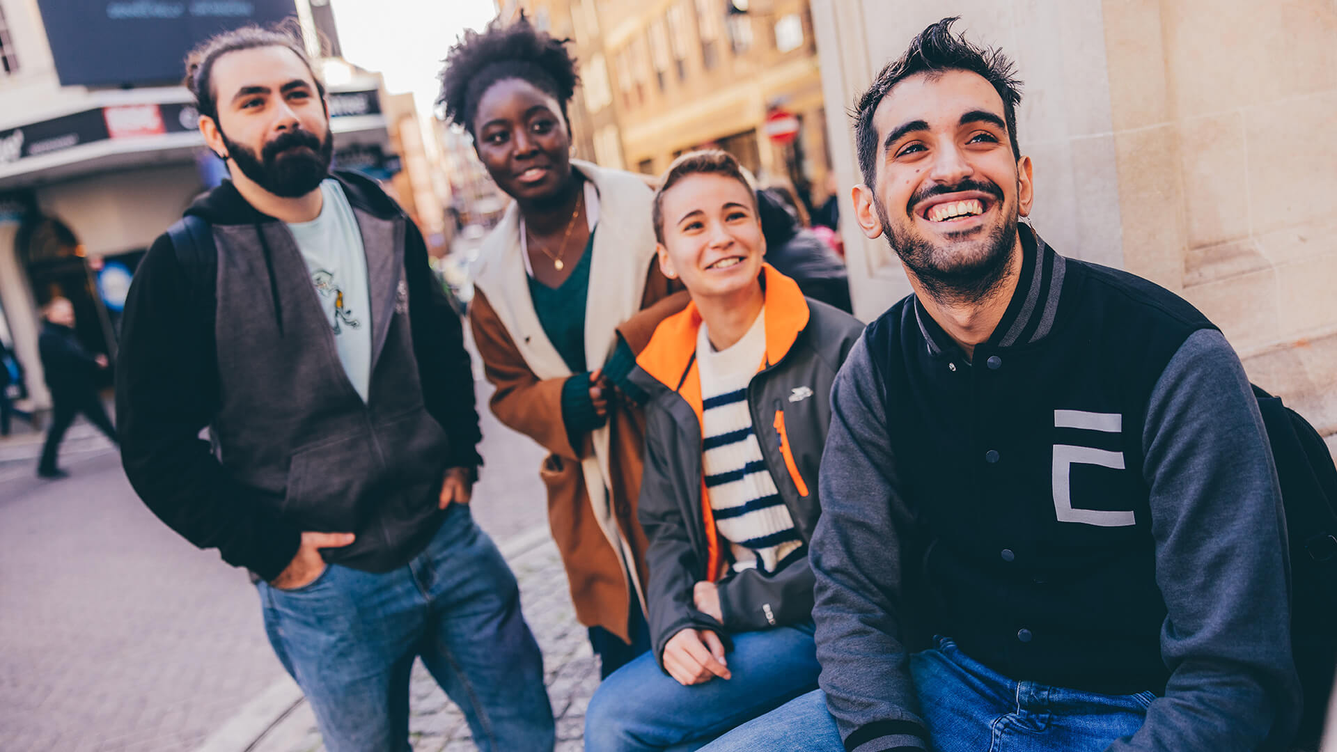 Four students smiling next to monument