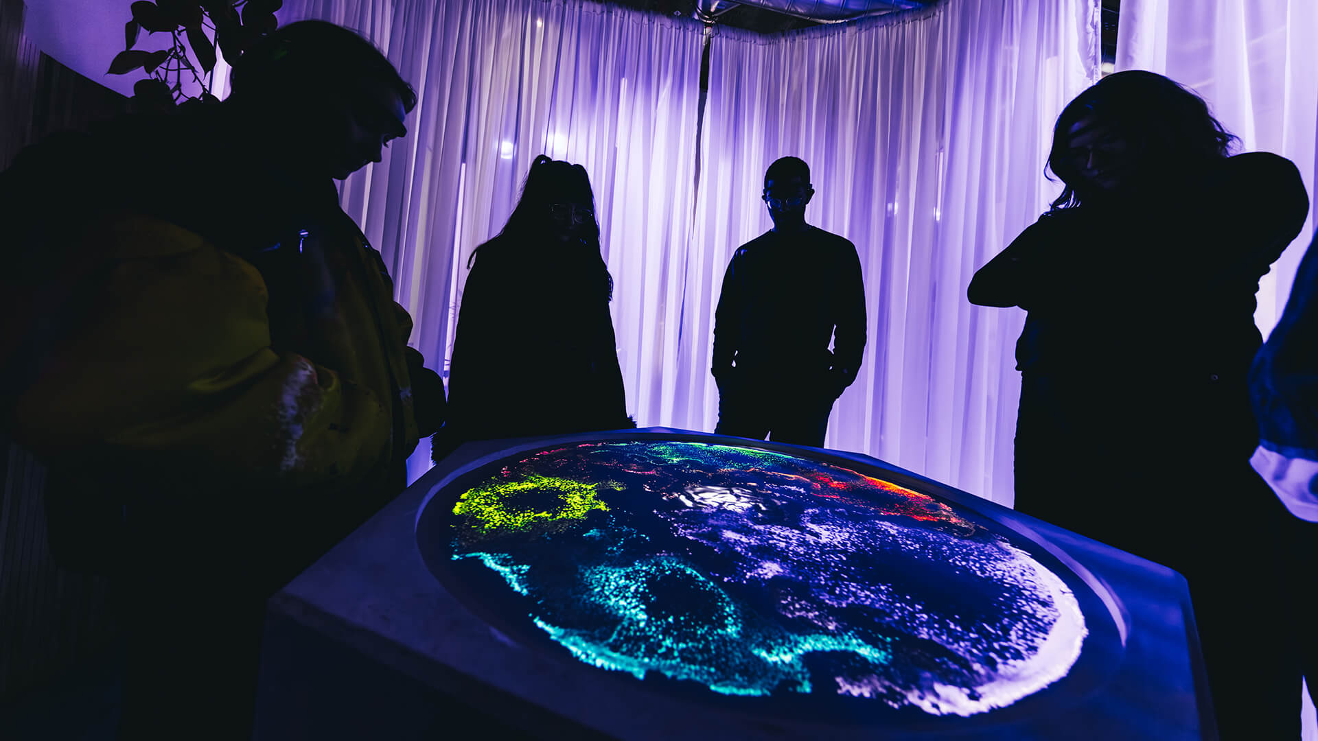 Immersive Media - Observatory Installation with four people looking at globe-like digital artwork