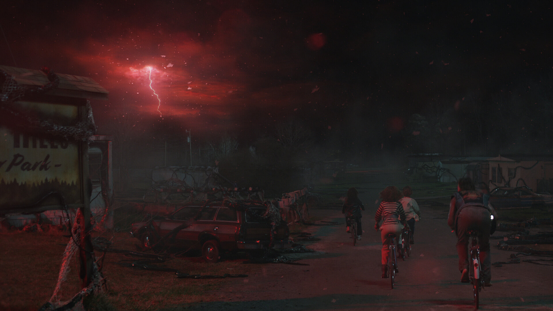 Four children cycling past red lightening storm