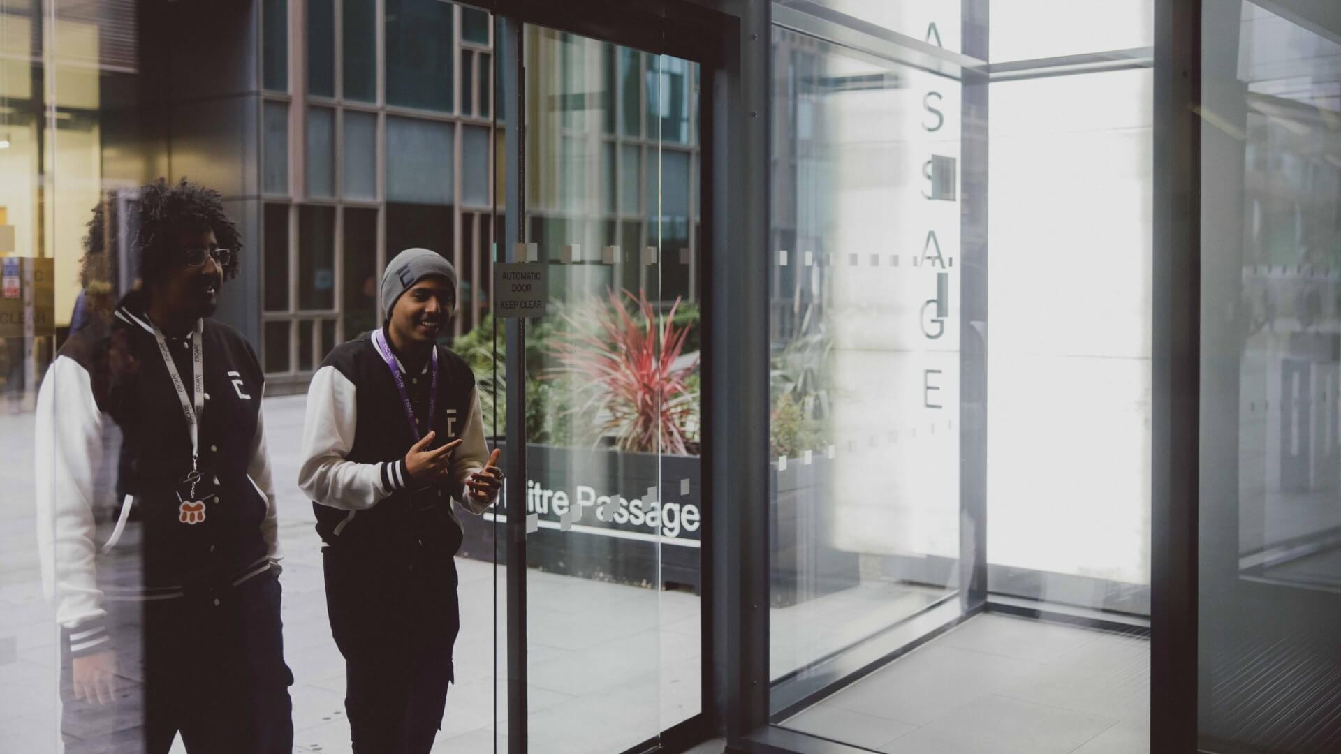 Two students walking into reception at 6 Mitre Passage