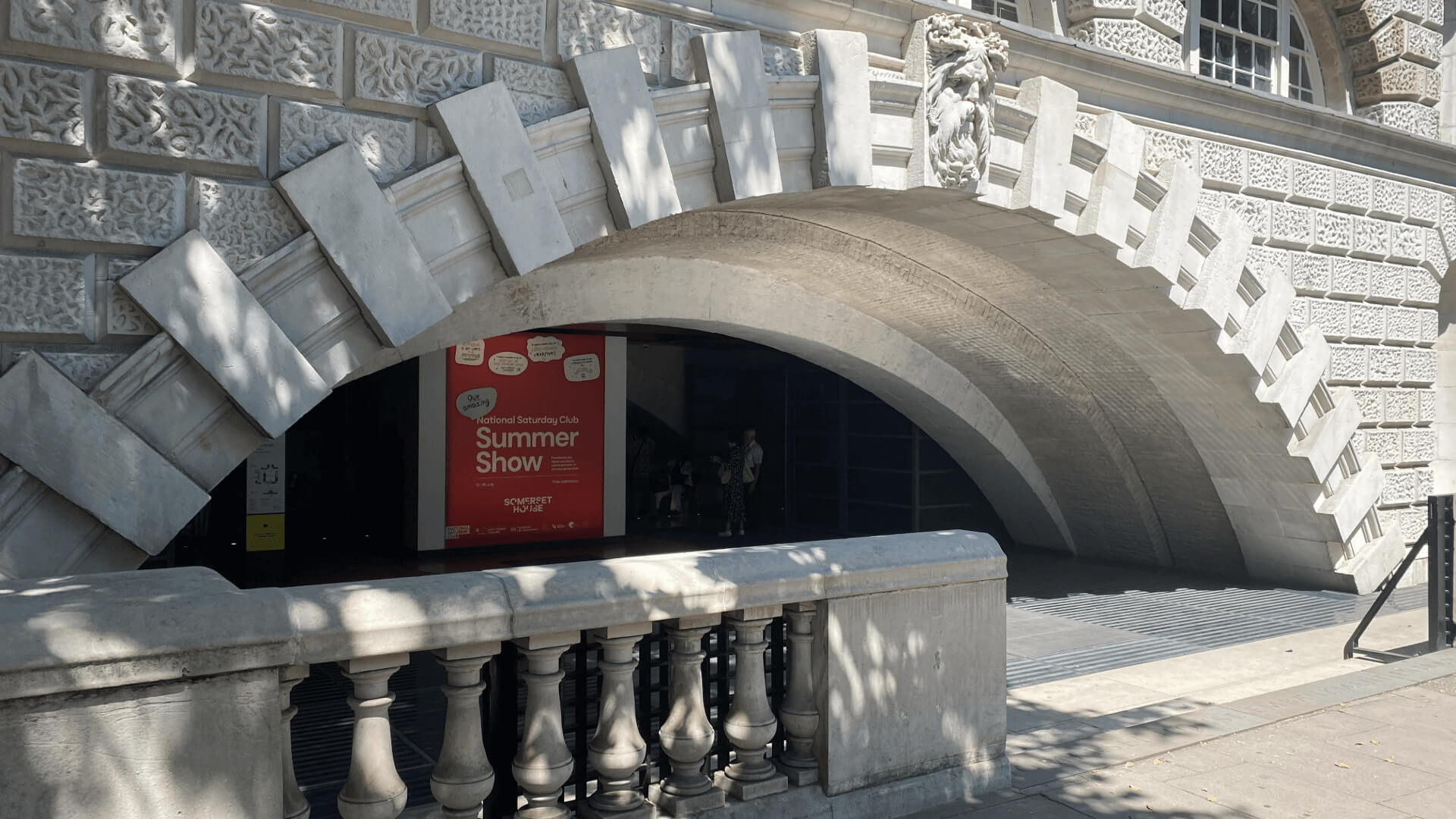A window at Somerset House with a sign saying "Summer Show" for the Saturday Club