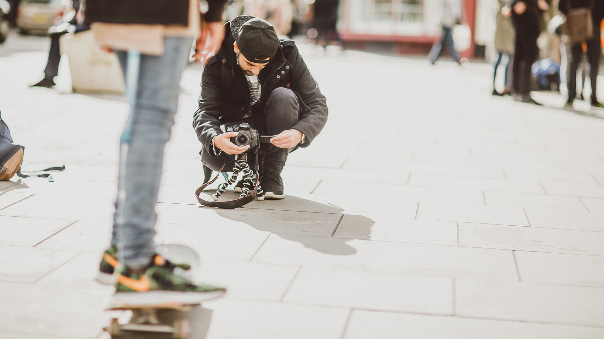 Male student taking photograph of skateboard
