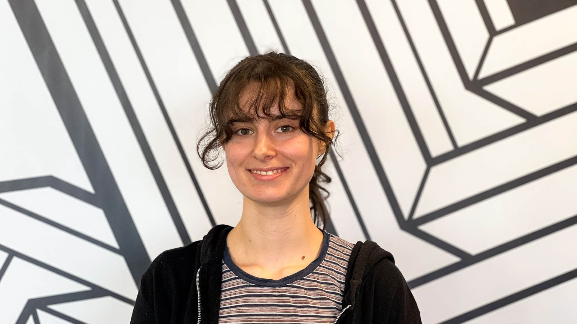 A head and shoulders picture of Clara against the Escape Studios black and white wall