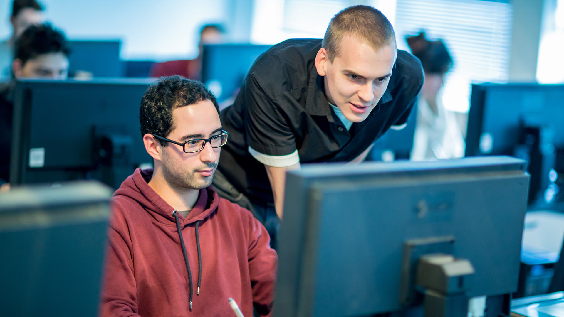 Tutor helping student at computer