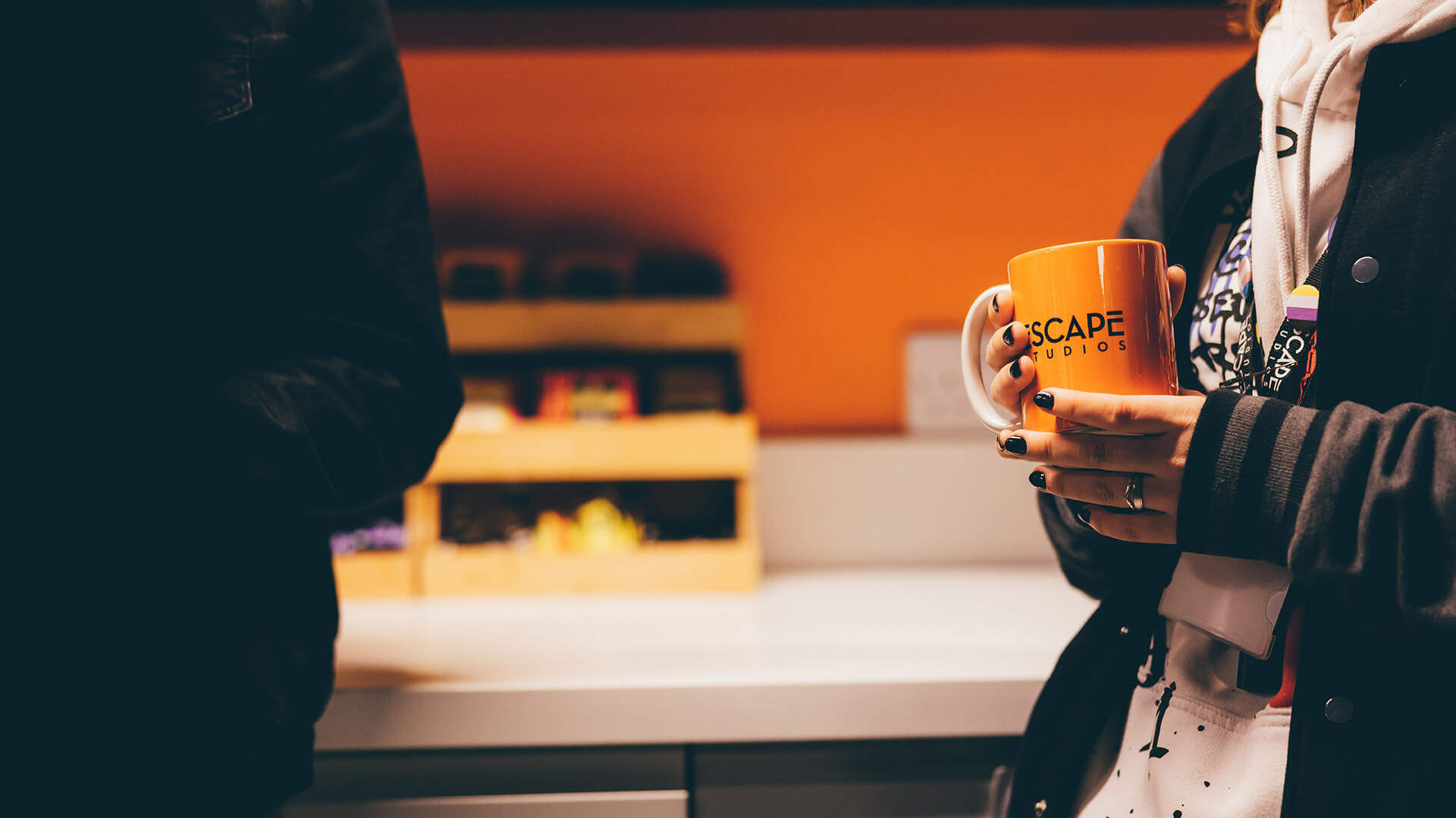 Female student holding an orange mug