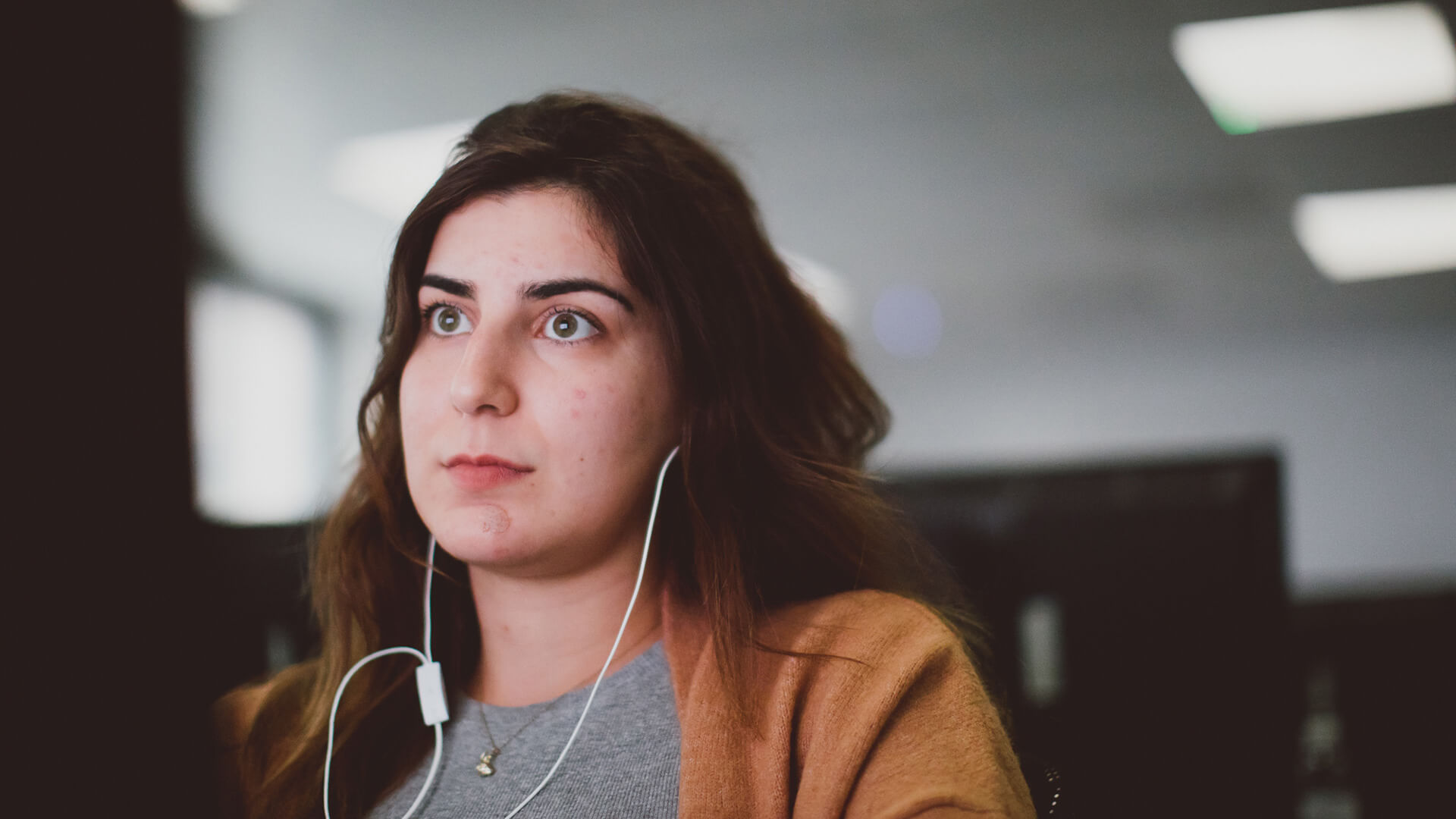 Female student wearing headphones at computer