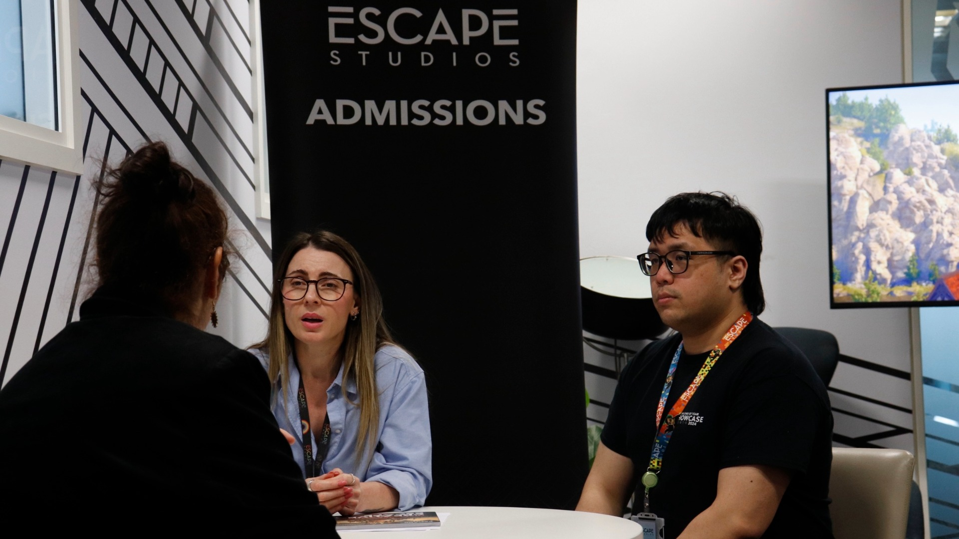 Admissions staff speaking to a guest at an Escape Studios open day.
