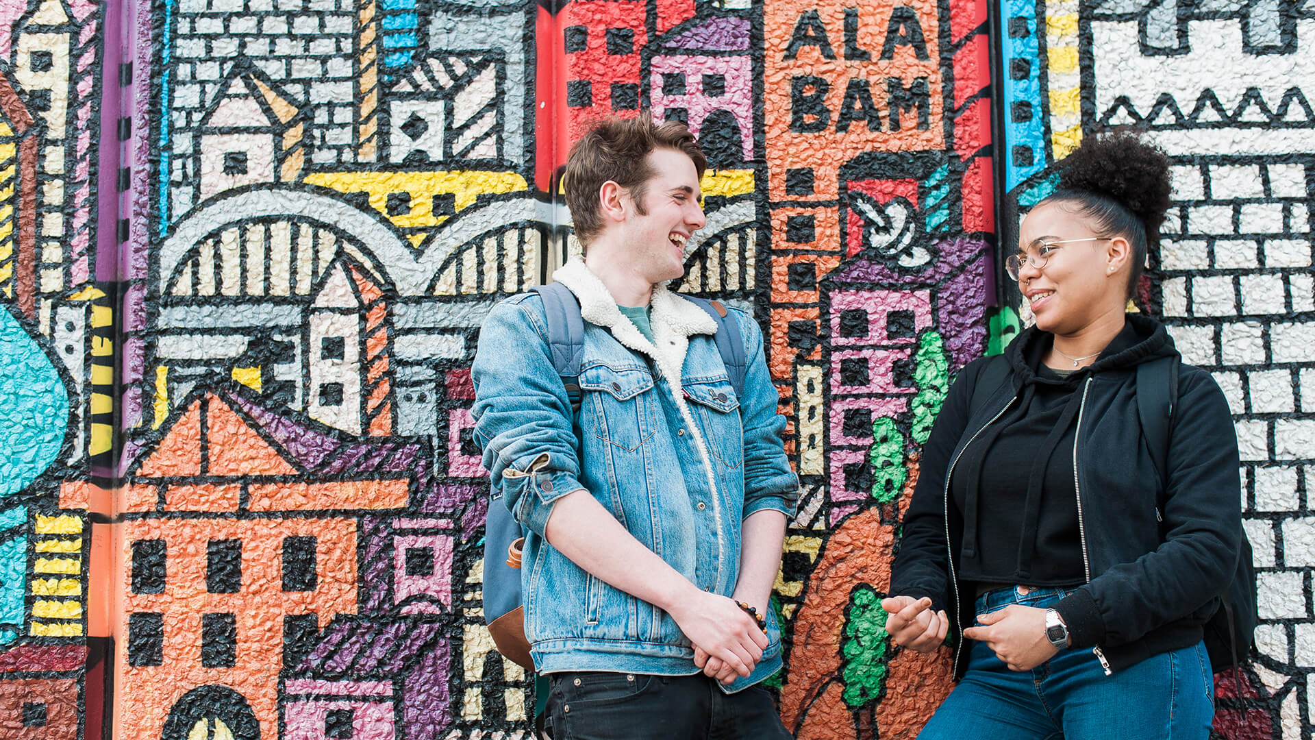 Two students against graffiti wall