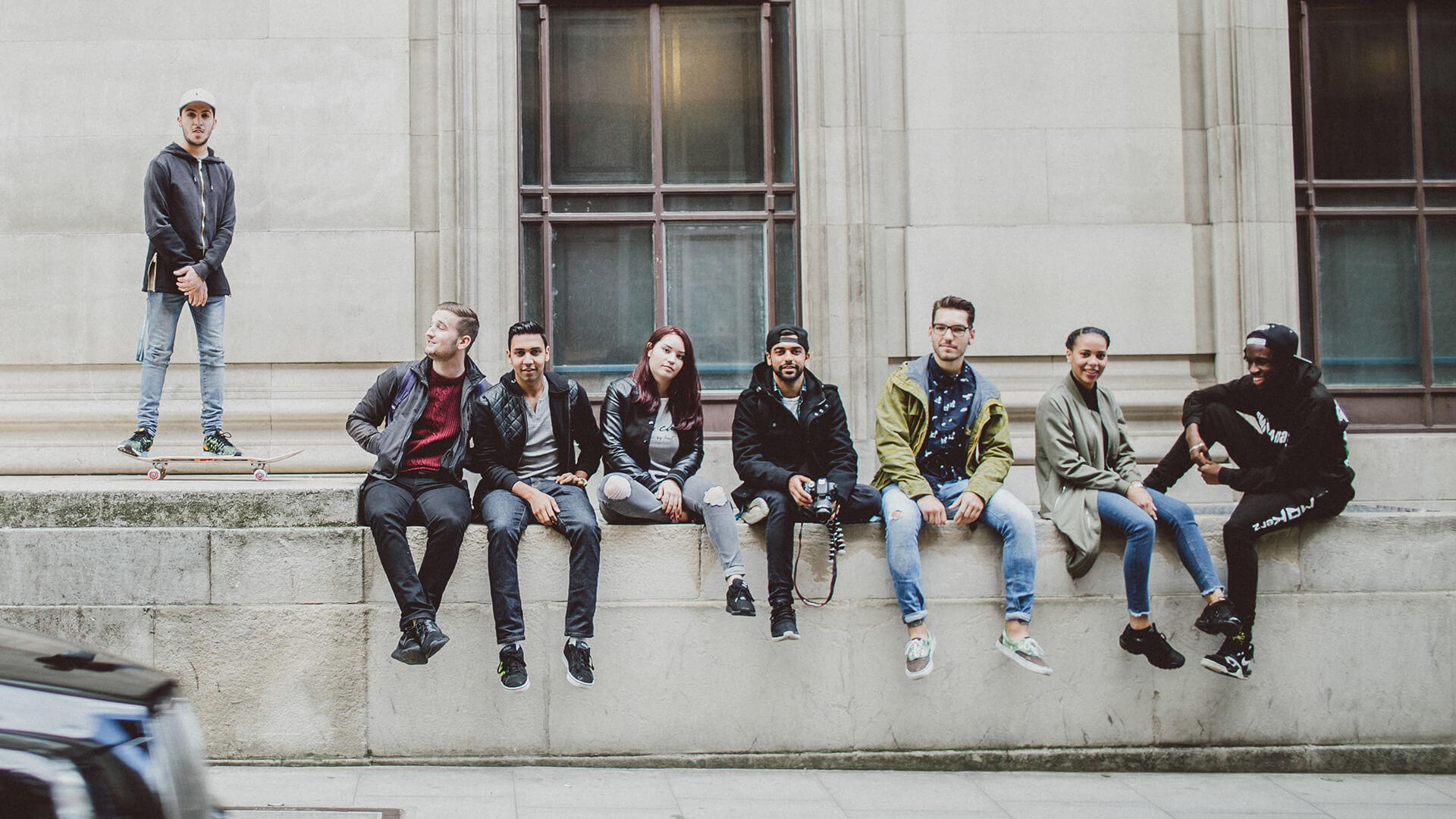 Group of students sat on wall