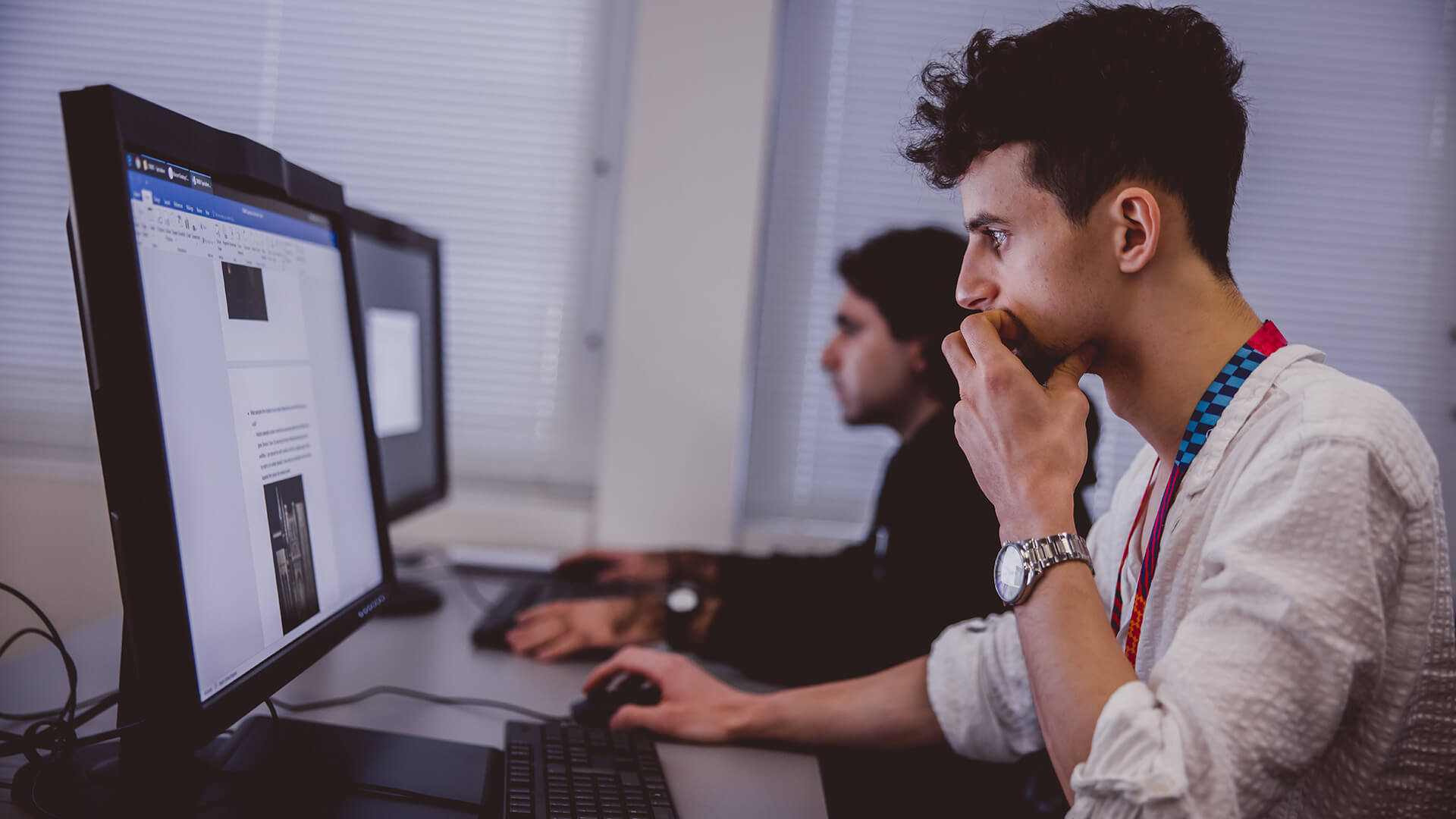 Male students sat using computers