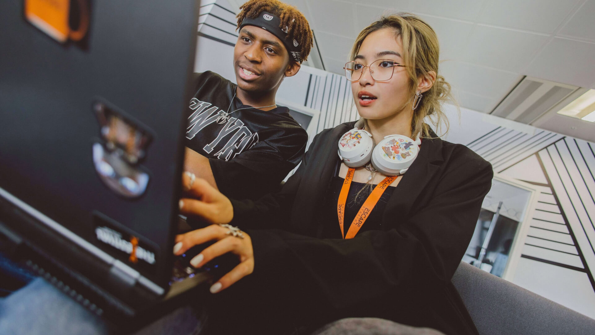 students sitting on laptop in the breakout space