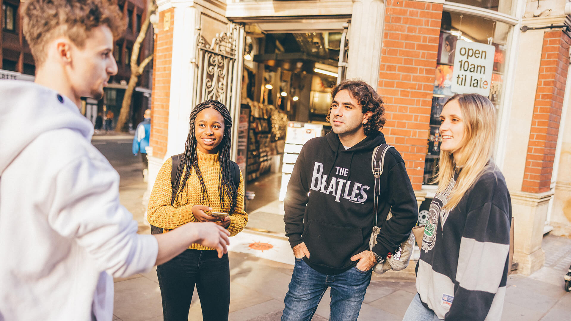 Four students talking outside a shop