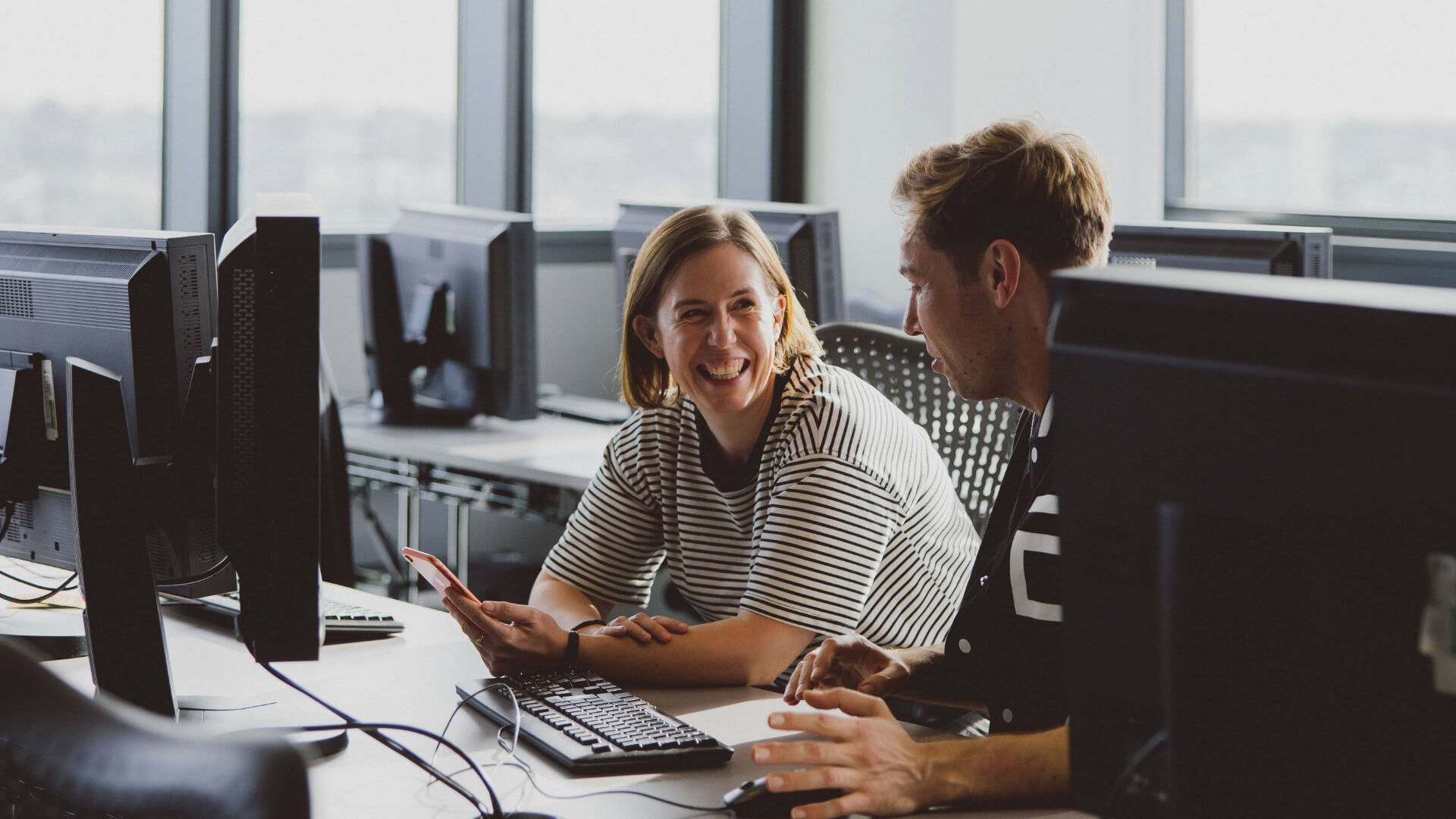 two people sitting at pcs talking