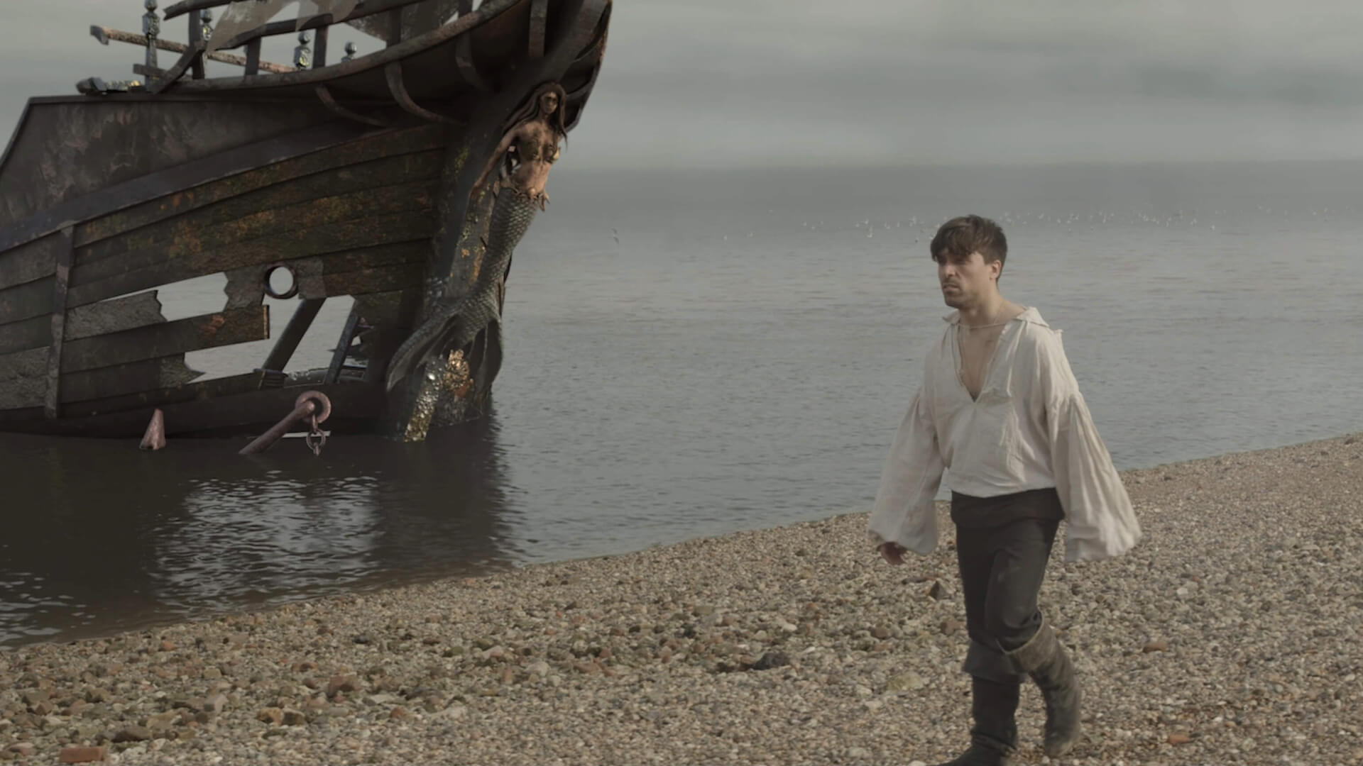 a pirate walks along a beach next a huge shipwreck