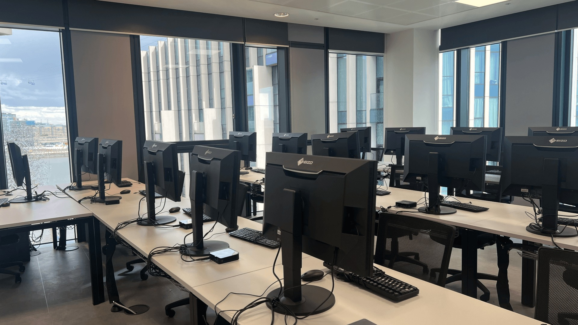 An empty studio classroom with computers and a view of the river out the window