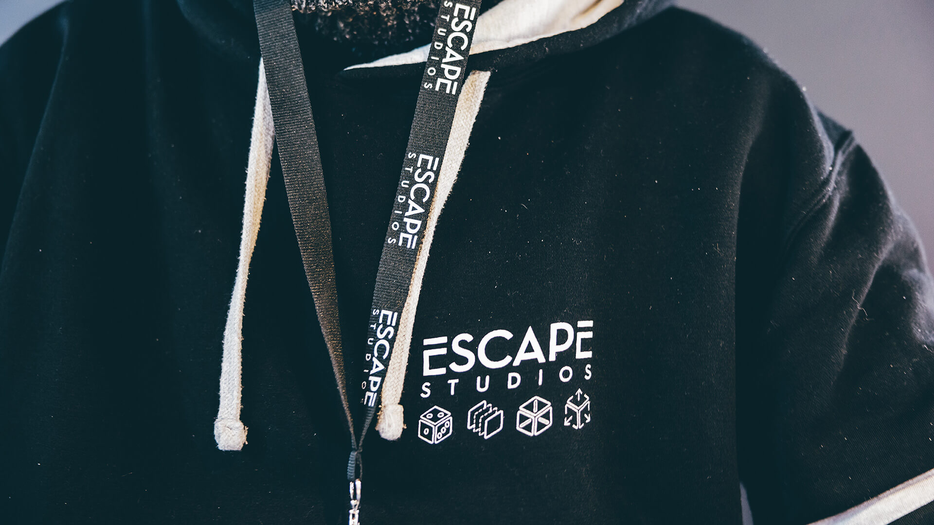 Black Escape lanyard over black Escape hoodie
