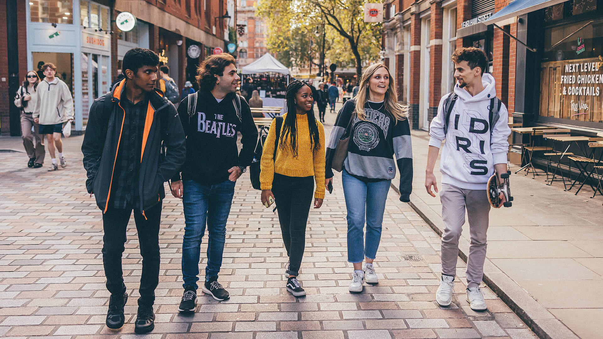Five students walking on the pavement