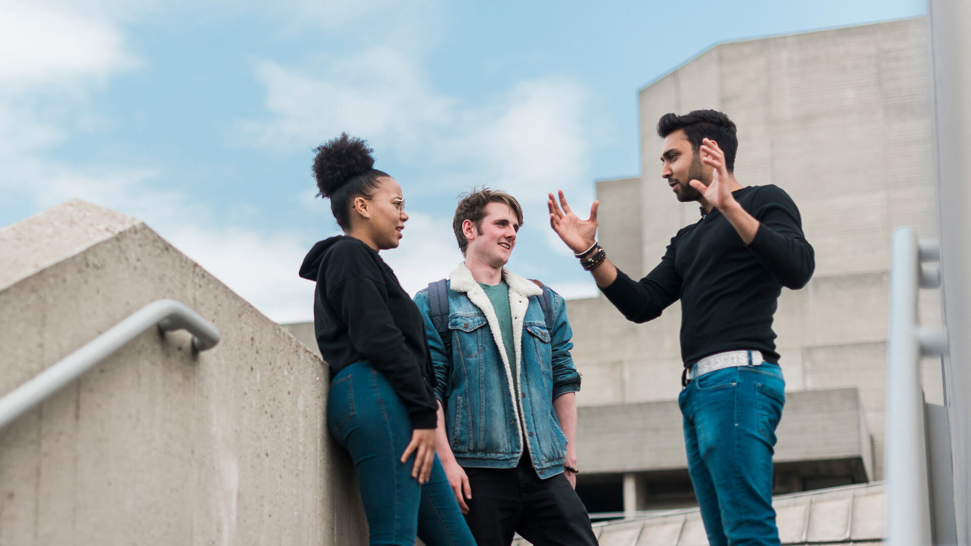 Three students talking on stone steps
