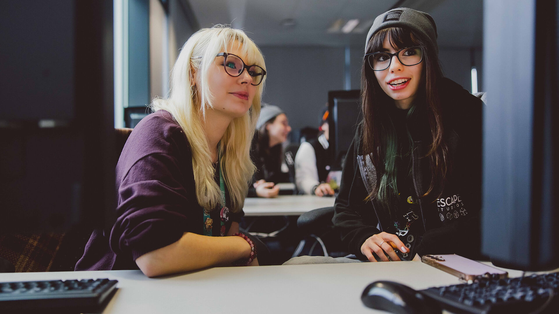 Two students in studio classroom looking at the computer