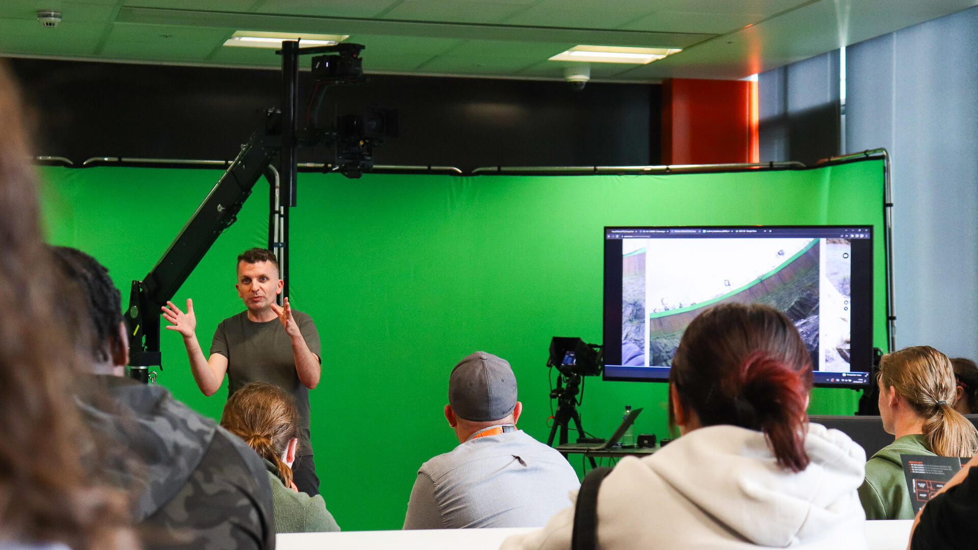 Tutor giving a presentation infront of a greenscreen