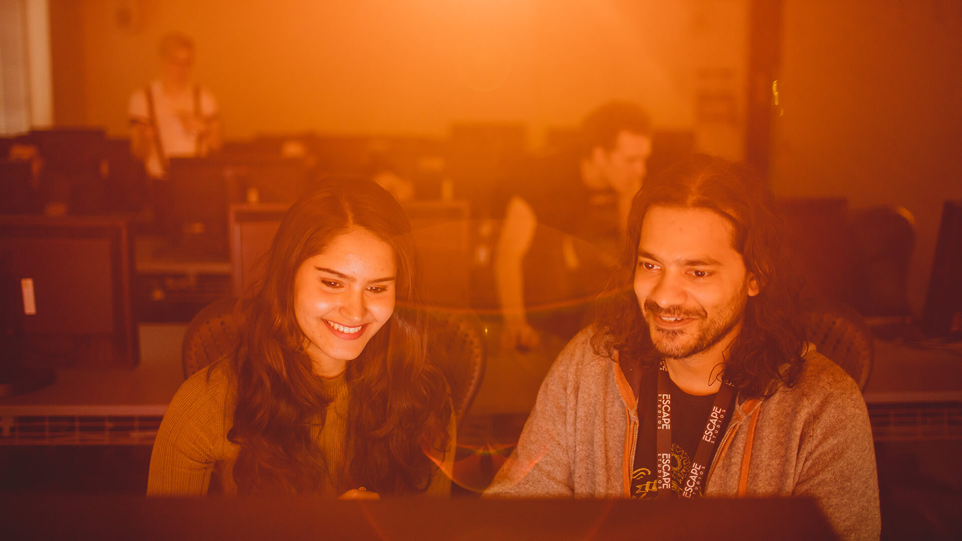 Two students working in orange light