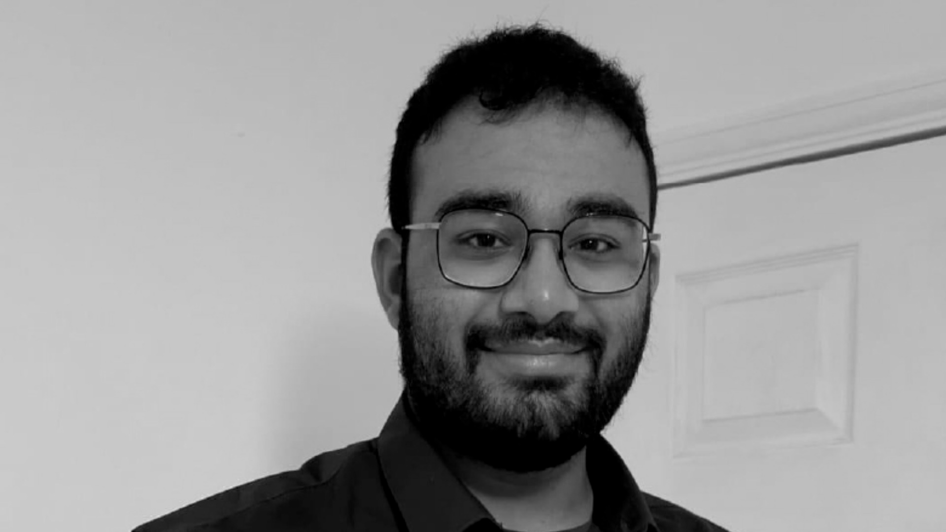 Headshot of Anand Shukla stood in front of a plain white wall.