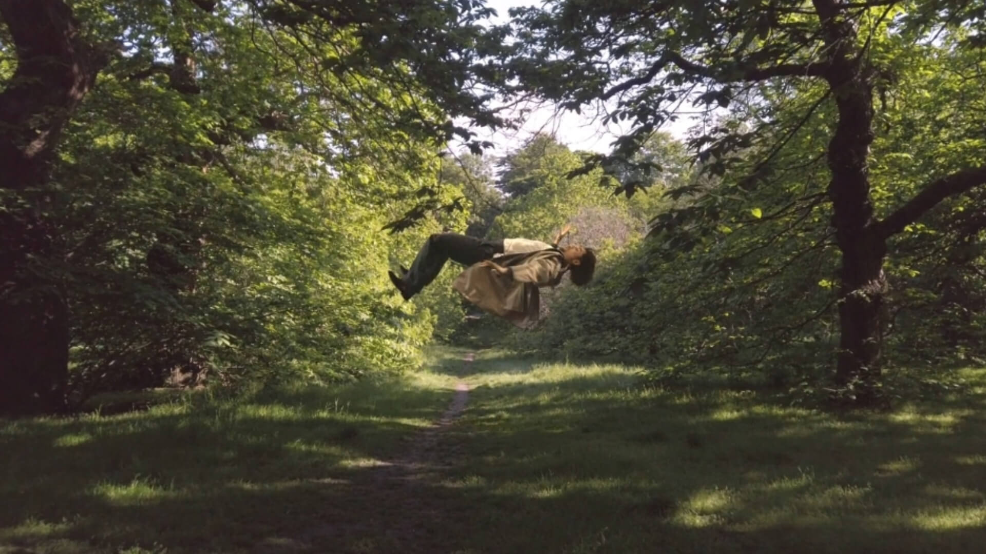 Person floating horizontally in the woods