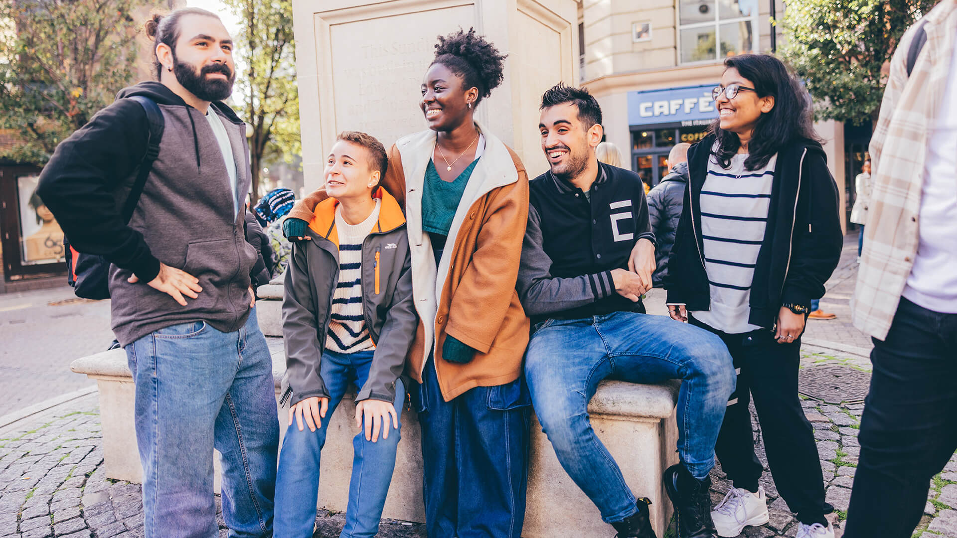 Group of students smiling at stone seating area