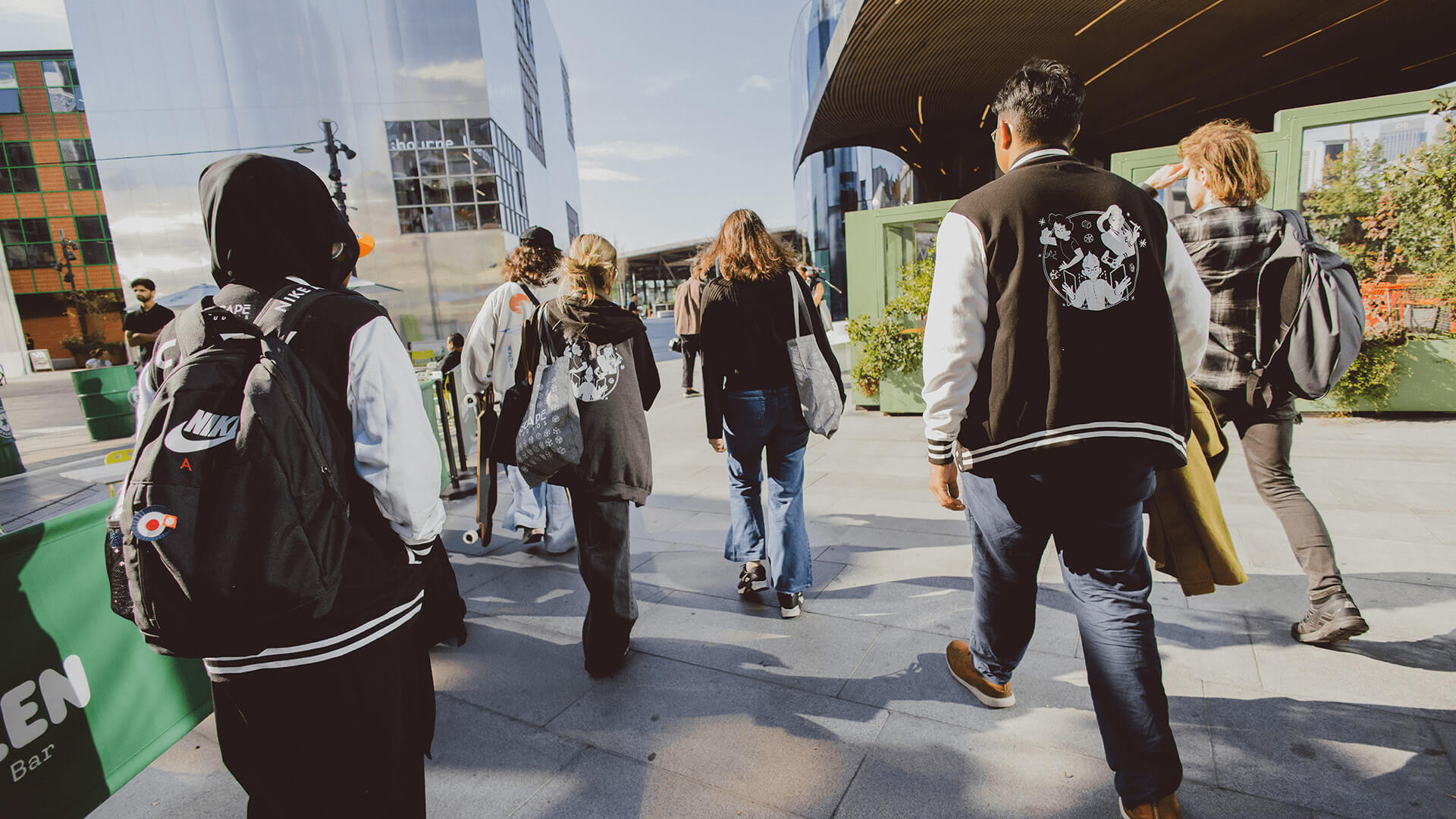 Group of students walking through pedestrianised area in North Greenwich
